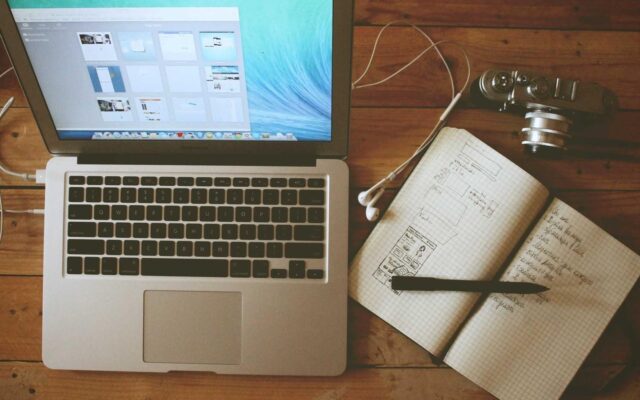 A laptop and notebook on a quiet, uncluttered desk