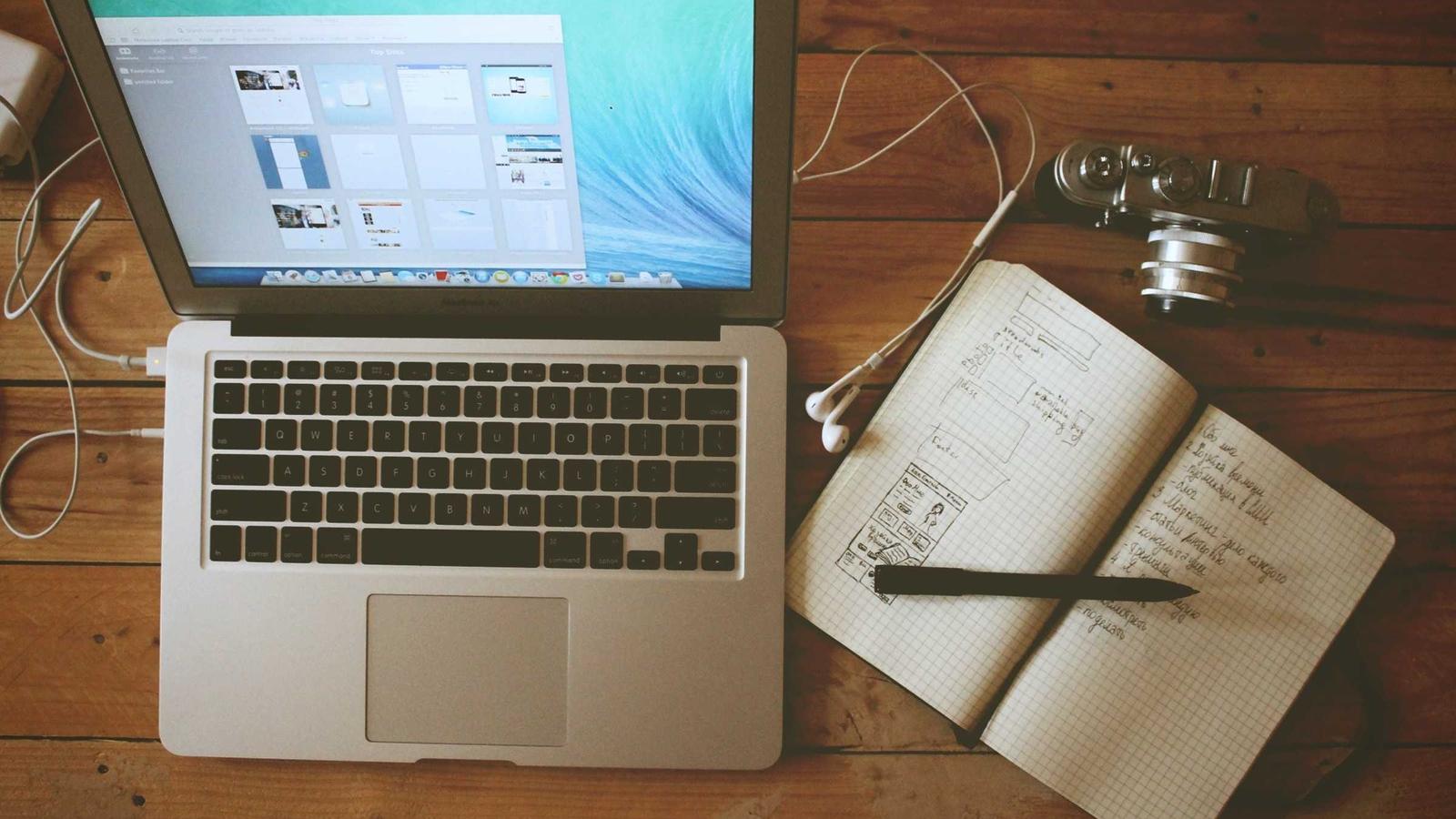 A laptop and notebook on a quiet, uncluttered desk